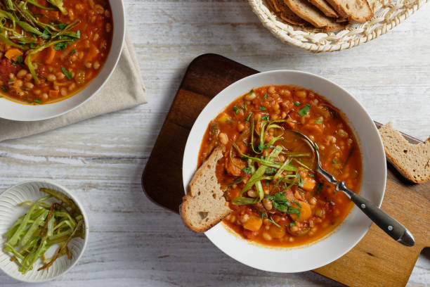 istock Bean stew with leeks, carrots and tomatoes. Garnished with fried strips of leek. 1405894121