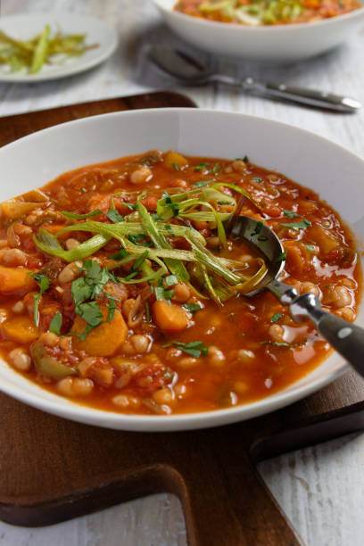 istock Bean stew with leeks, carrots and tomatoes. Garnished with fried strips of leek. 1405894684