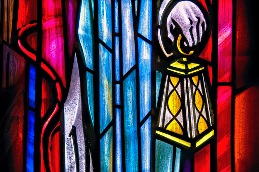 hand holding lanterns in stained glass