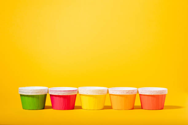 istock Multi-colored paper molds for muffins and cupcakes on a yellow background 1405895030