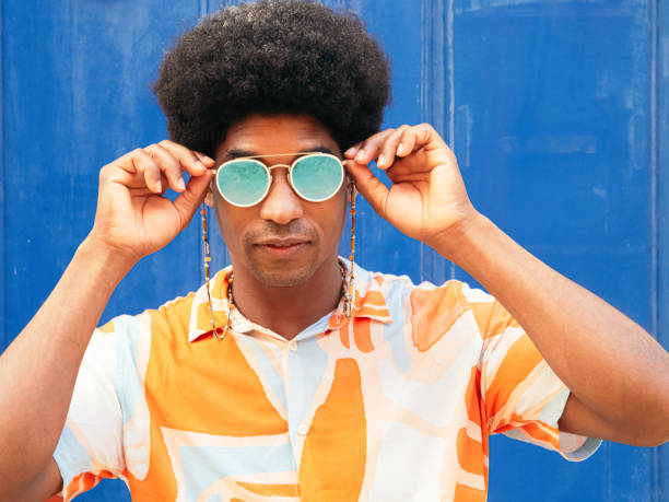 istock Afro man puts on sunglasses on the street. 1405896226