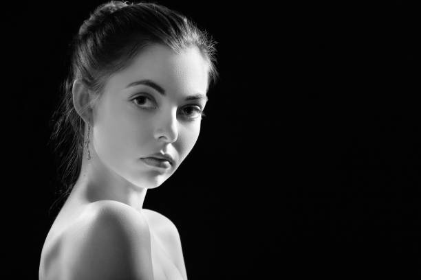 istock sad beautiful woman looking at camera on black background with copy space, monochrome 1405898087