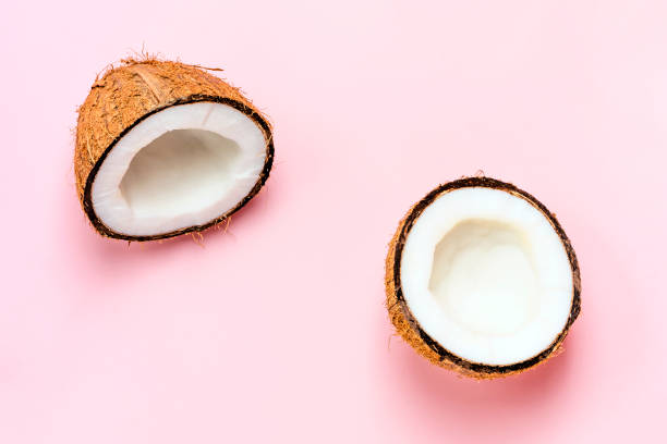 istock Coconut halfs on pastel pink background. Close-up. 1405906613