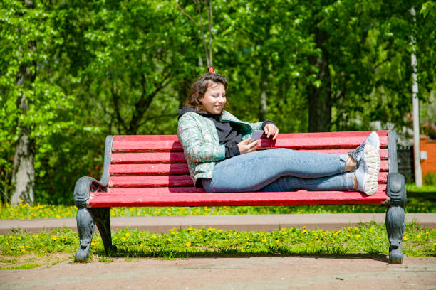 istock Young woman sitting on a bench 1405906888
