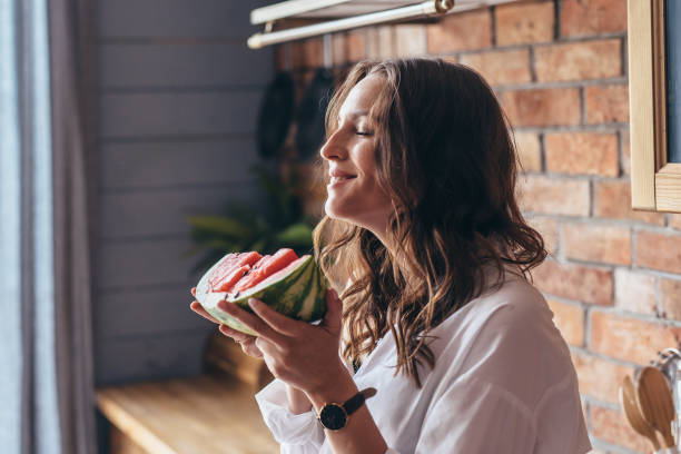 istock Woman at home eating watermelon in the kitchen 1405906944