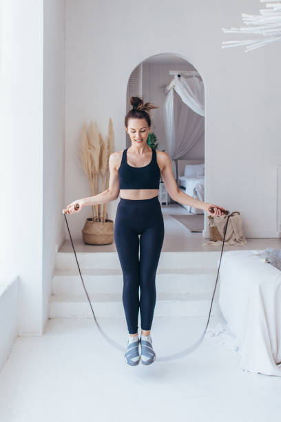 istock Fit woman with jump rope at home doing skipping workout. 1405906959