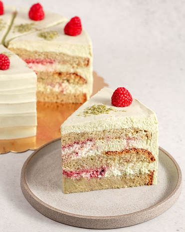 Slice of layered vanilla cake with vanilla icing. 