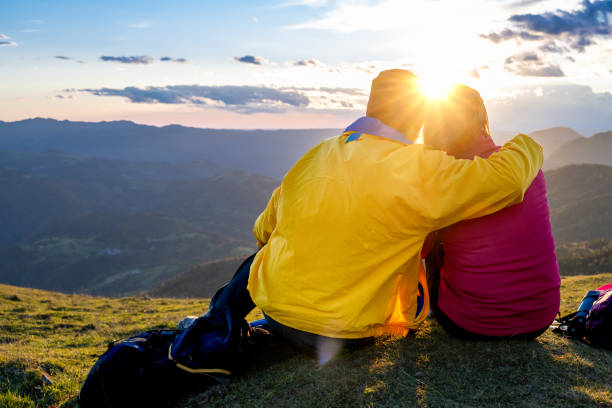 istock Couple sitting in evening nature and embracing around shoulders 1405908134