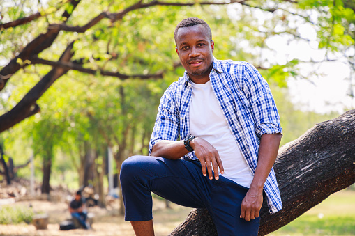 Portrait of a Happy young African American man looking at the camera at the park. Confident people