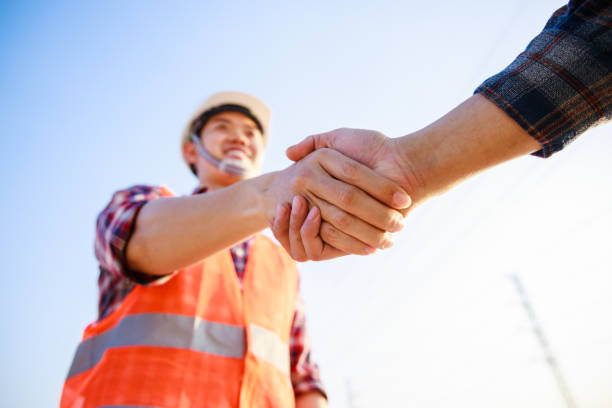 istock Silhouette of Two Architect At Construction Site Shaking Hand. Business handshake concept 1405911139