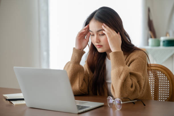 istock Office syndrome. Overworked tired young asian woman feeling headache, having eyesight problem after computer laptop work. Stressed young woman suffering from fatigue at home 1405915634