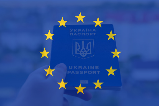 Defocus European union and Ukraine. Ukrainian passport. Support and help Ukraine, Independence Constitution Day, National holiday. Hand holding flag. Union. Out of focus.