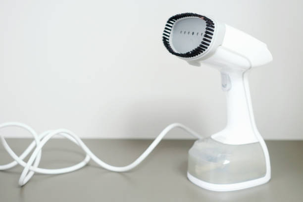 istock White portable steamer close-up on gray background. 1405920073