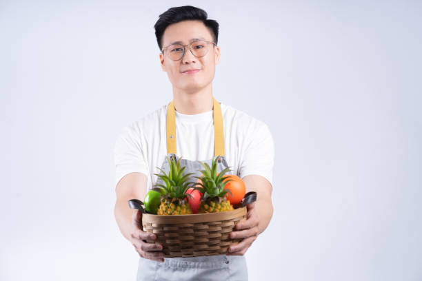 istock Image of young Asian waiter on background 1405923707