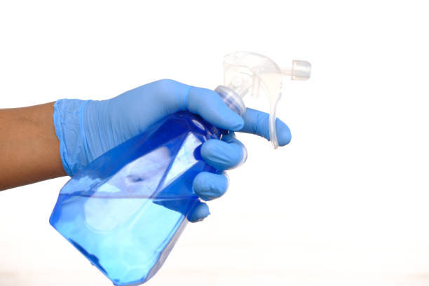 istock hand in blue rubber gloves holding spray bottle with copy space 1405924888