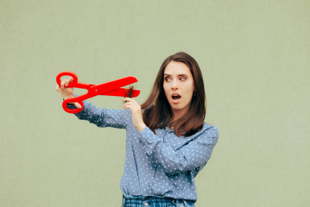 istock Woman Using Giant Scissors to Cut of Split Ends 1405924971