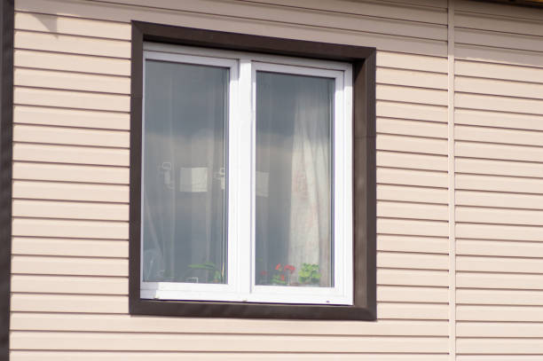 istock Plastic white window on the beige wall house from the siding 1405932548