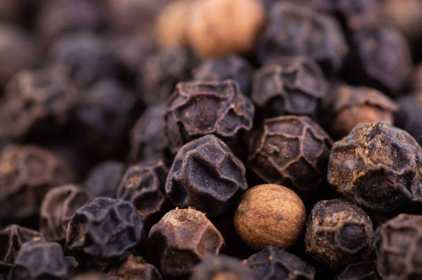 closeup background of black pepper seeds texture closeup background of black pepper seeds texture. black peppercorn stock pictures, royalty-free photos & images