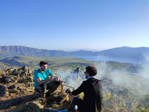 istock Two mountaineering friends sitting and chatting around the fire for coffee 1405934881