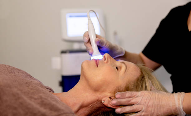 Woman at the spa getting a light therapy beauty treatment on her face Senior woman at the spa getting a beauty treatment on her face using ultrasound and light therapy light therapy stock pictures, royalty-free photos & images