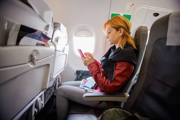 istock Woman on plane flight paying with mobile app for the accommodation 1405943389