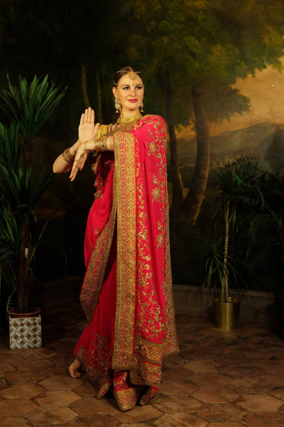 伝統的なインドの花嫁である赤いサリーを着た若い女性が踊り、微笑みます。 - indian costume ストックフォトと画像