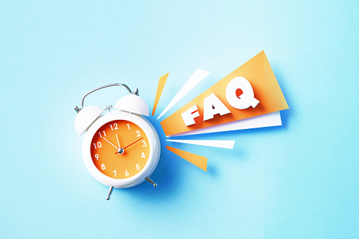 FAQ reads next to white alarm clock on blue background. Horizontal composition with copy space. FAQ concept.