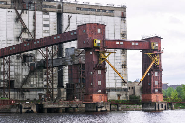 istock Old abandoned granary elevator and grain bin on the bank of a navigable river. 1405947189