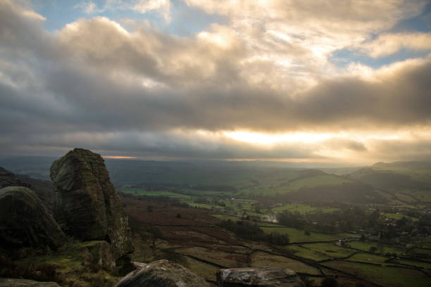 Stormy sunset over hills and field stock photo