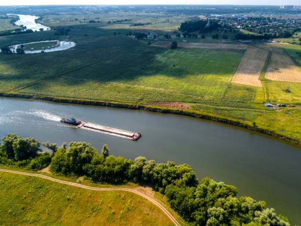 istock Towboat transports barge with sand along tranquil river 1405950886