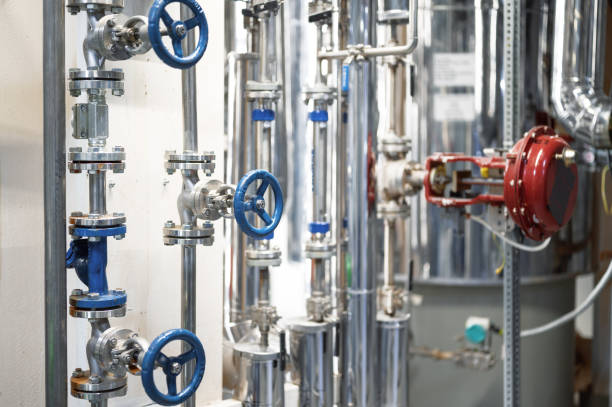 istock Thin metal pipes with small blue valves and flanges at plant 1405951033