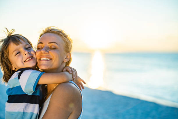 istock Loving single mother and son embracing on the beach. 1405952555