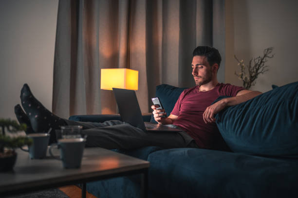 istock Caucasian Single Man Sitting On The Couch And Working From Home 1405953143