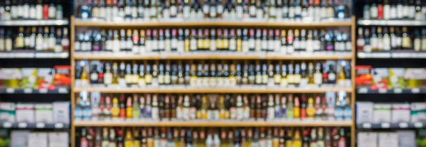 スーパーマーケットの店の背景にある酒類のアルコール棚の抽象的なぼかしワインボトル - wine wine bottle drink alcohol ストックフォトと画像
