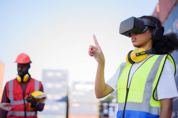istock African-American female engineers wearing VR Headset look container cargo ship. 1405959633