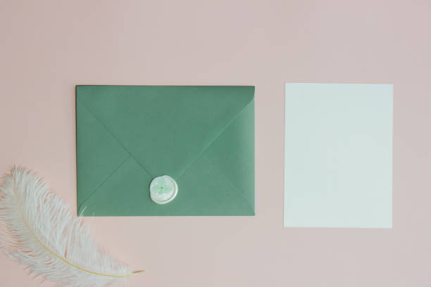 istock Green envelope with white letter and feather over the pink background. 1405959759