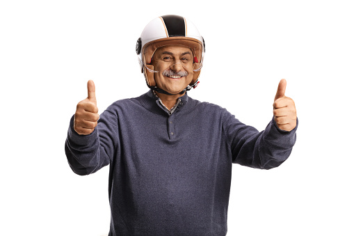 Cheerful mature man with a motorbike helmet showing thumbs up isolated on white background