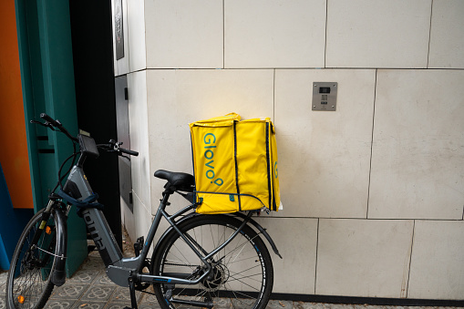 Barcelona, Spain - 21 June 2022: A bicycle with a Glovo delivery app bag on its rear