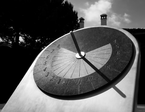 Sundial pareidolia where you can see the smile of the Cheshire Cat, where the chimneys are his ears and the hours of the clock his jokey smile in black and white