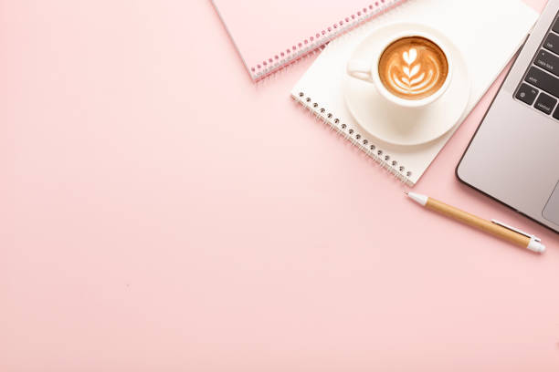 istock Notebook, a cup of coffee with a beautiful pattern and a notepad on a pink background. Place for text 1405962488