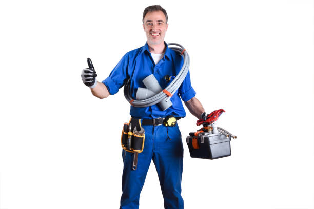 Portrait of uniformed plumber with work tools in hands with ok sign and white isolated background. Front view. Horizontal composition.