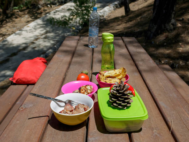 Wooden picnic table with food and water in the forest