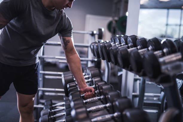 Close-up of man's hands taking dumbbell stock photo