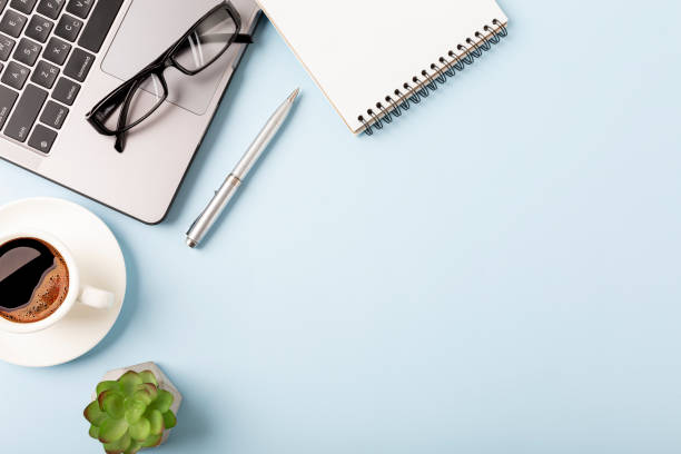 istock Business desk workplace and office objects over blue backdrop. Top view flat lay with copy space for your text 1405969378