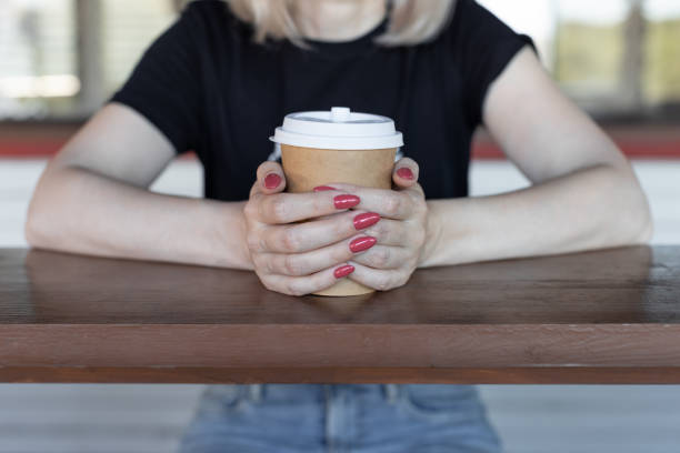 istock female hands holding a paper cup with coffee 1405971884