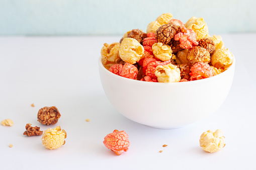 Colorful popcorn in a white bowl, Is snack for everyone.