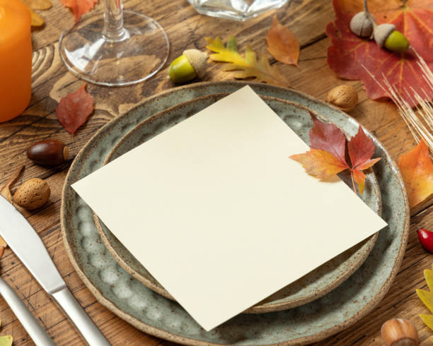 istock Autumn rustic  table setting with red, yellow and orange leaves, berries and blank card close up, mockup 1405973828