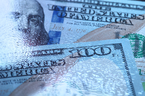 Hundred dollar bill in abstract lighting, close-up.