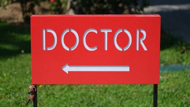 Red table with word doctor and arrow. Signpost for medical care concept