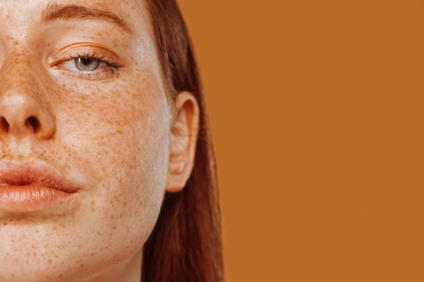 close-up portrait of half face of a red-haired girl with freckle - human eye eyebrow eyelash beauty imagens e fotografias de stock